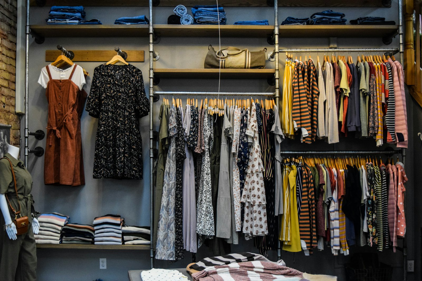 Bunte Kleidung an Kleiderstangen und in Regalen